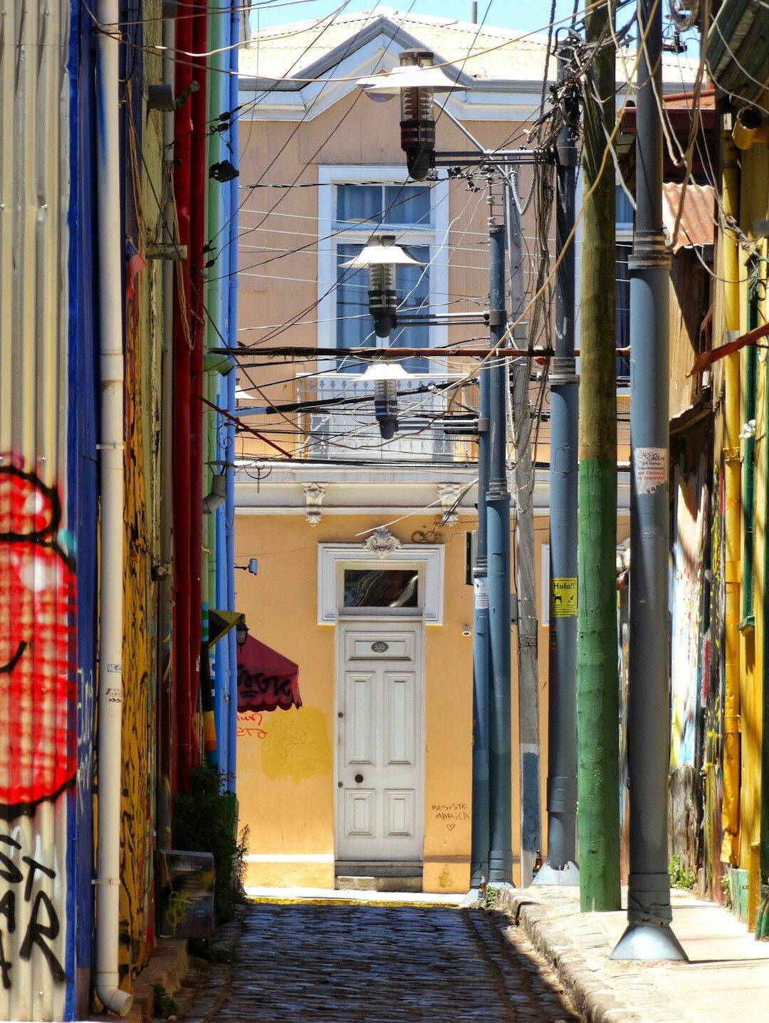 Narrow colorful street in Valparaiso with colorful houses and hanging cables